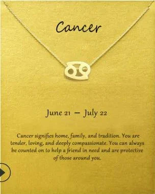 Cancer zodiac sign pendant necklace on a gold link chain with description card.