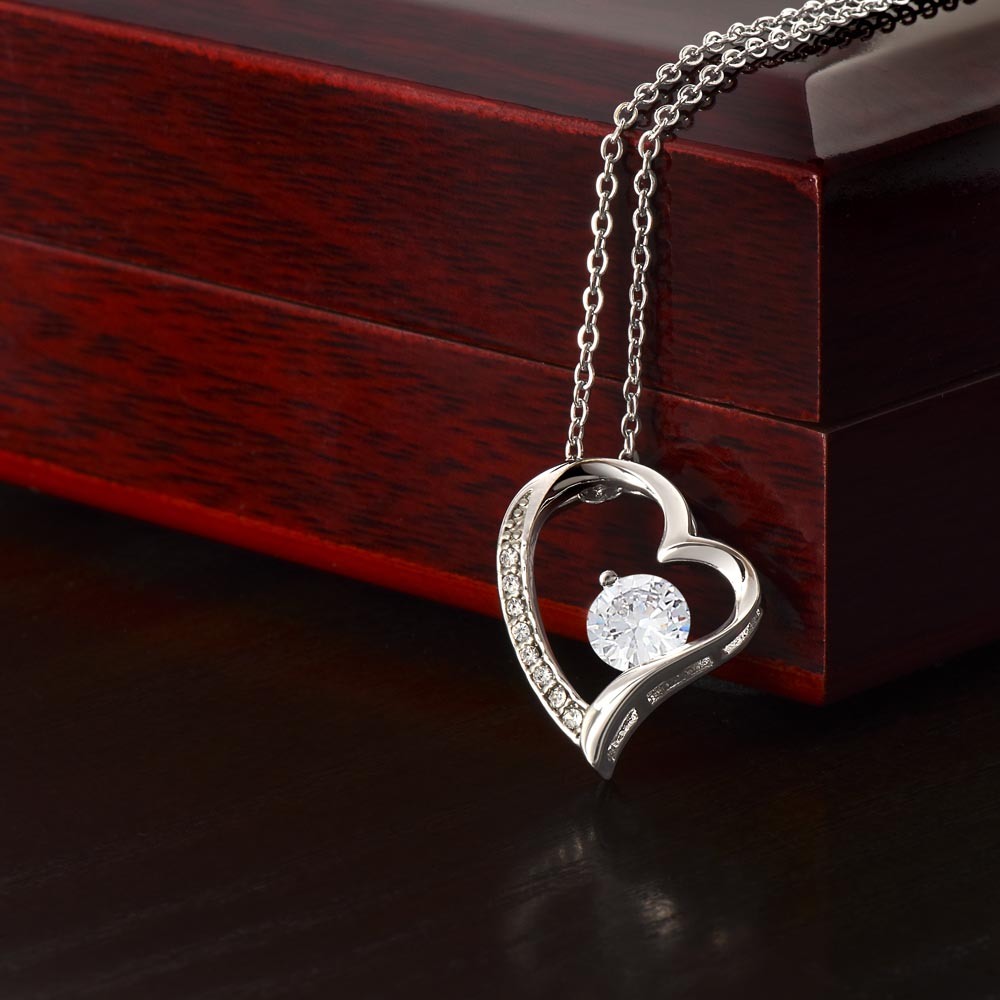 Wife heart necklace with CZ crystal in polished heart pendant on wooden background.