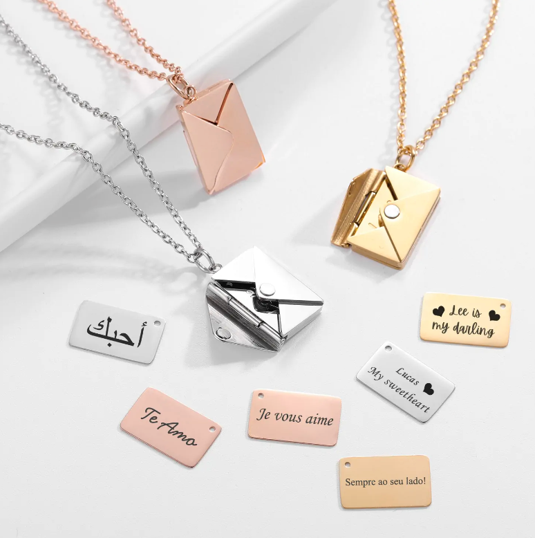 Sterling silver and gold envelope necklaces with customizable engraved message plates.